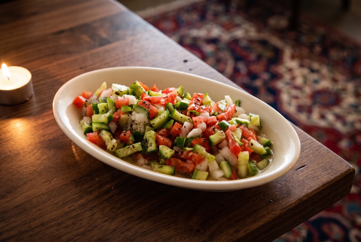 Small Shirazi · A small bowl of finely diced cucumber, tomato, and onion tossed with lime juice and dried mint, the crisp,…
